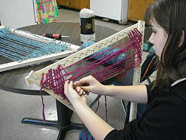 girl weaving on tri-frame